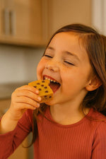 Young girl enjoying a Peanut Butter Chocolate Chip Blondie with clean, high-protein, gluten-free ingredients.