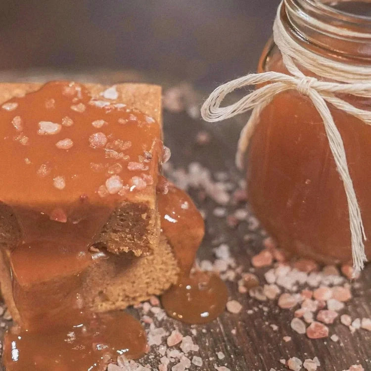 Salted caramel blondie bar next to a jar of caramel sauce.