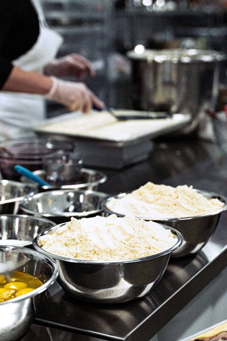 Protein Snack Shop kitchen with bakers preparing clean, small-batch protein snacks using real whole-food ingredients